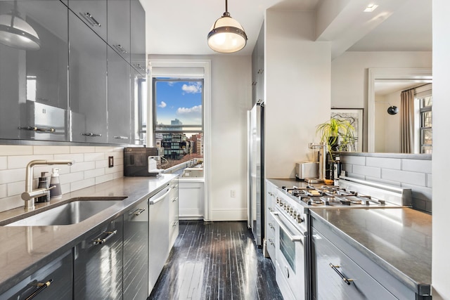 105 E 15th St Unit 106, New York City, NY 10003 - kitchen with appliances with stainless steel finishes, a sink, dark wood-style flooring, decorative backsplash, and dark stone countertops