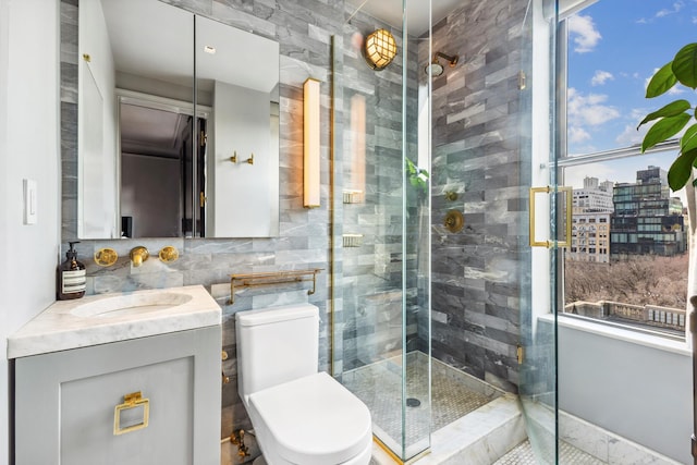 105 E 15th St Unit 106, New York City, NY 10003 - bathroom with vanity, a shower stall, toilet, healthy amount of natural light, and tile walls