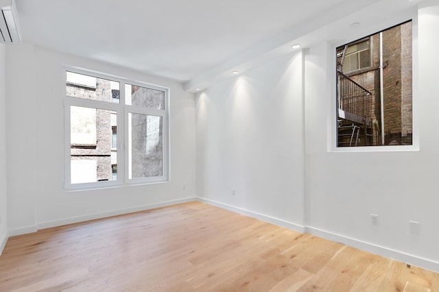 241 W 107th St Unit 2-Flr, New York City, NY 10025 - empty room with wood finished floors, a wall mounted air conditioner, baseboards, and recessed lighting