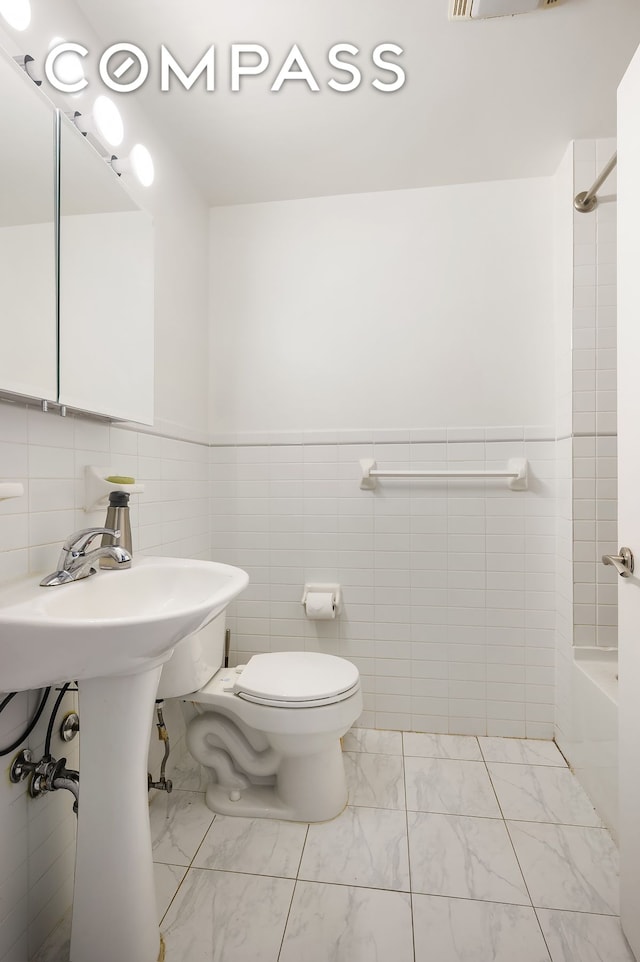 29 W 138th St Unit 5A, New York City, NY 10037 - full bathroom featuring tile walls, toilet, marble finish flooring, and shower / washtub combination