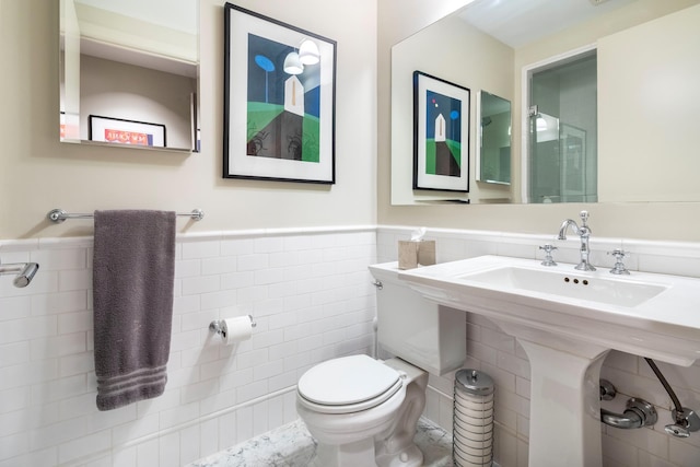 43 W 64th St Unit 6A, New York City, NY 10023 - bathroom with tile walls, wainscoting, toilet, and a sink