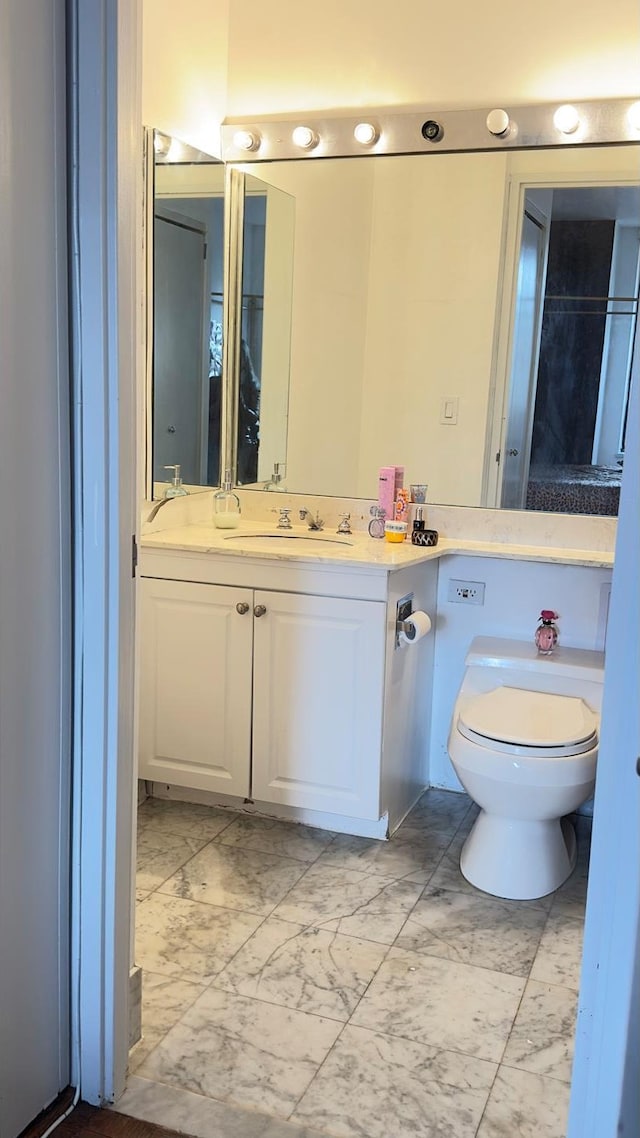 311 E 38th St Unit 12C, New York City, NY 10016 - bathroom featuring marble finish floors, toilet, and vanity