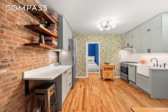 334 E 5th St Unit 2, New York City, NY 10003 - kitchen with light countertops, light wood-style flooring, open shelves, wallpapered walls, and stainless steel gas stove