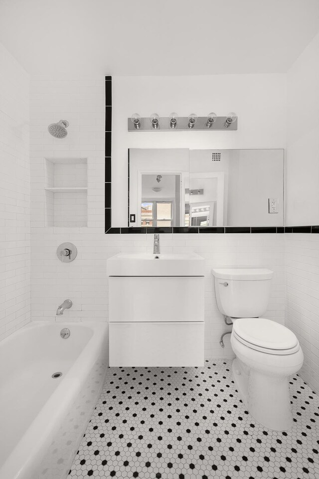 77 7th Ave Unit 9T, New York City, NY 10011 - full bath with tile walls, tile patterned flooring, vanity, and shower / bath combination