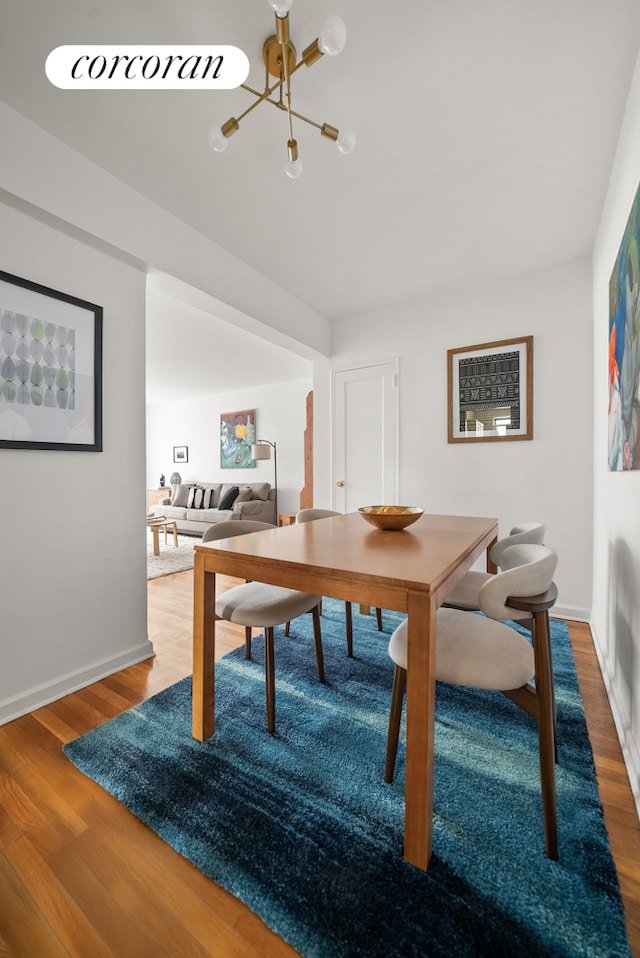 202 Seeley St Unit 2E, New York City, NY 11218 - dining area featuring a chandelier, wood finished floors, and baseboards