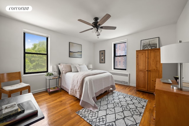 202 Seeley St Unit 2E, New York City, NY 11218 - bedroom with radiator heating unit, light wood-type flooring, baseboards, and ceiling fan