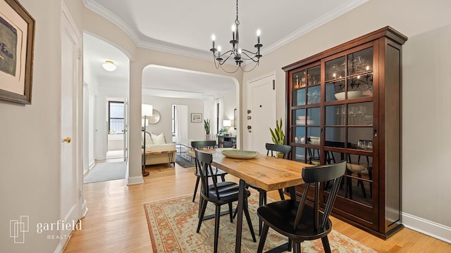 20 Plaza St E Unit A-8, New York City, NY 11238 - dining area with arched walkways, light wood-type flooring, ornamental molding, a chandelier, and baseboards