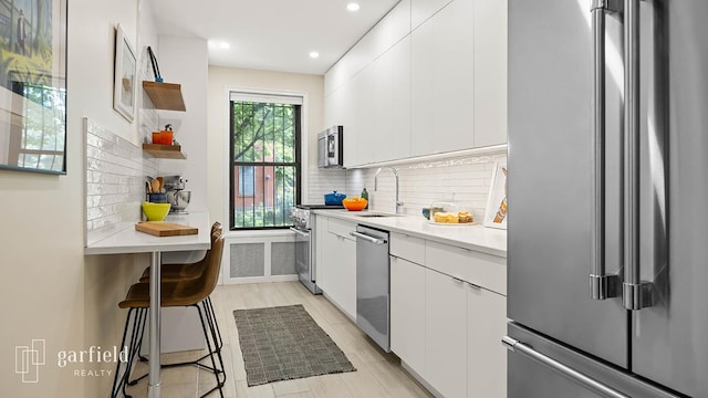 20 Plaza St E Unit A-8, New York City, NY 11238 - kitchen featuring high quality appliances, open shelves, a sink, white cabinets, and light countertops