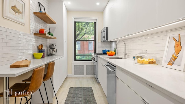 20 Plaza St E Unit A-8, New York City, NY 11238 - kitchen featuring stainless steel appliances, a sink, open shelves, light countertops, and white cabinets