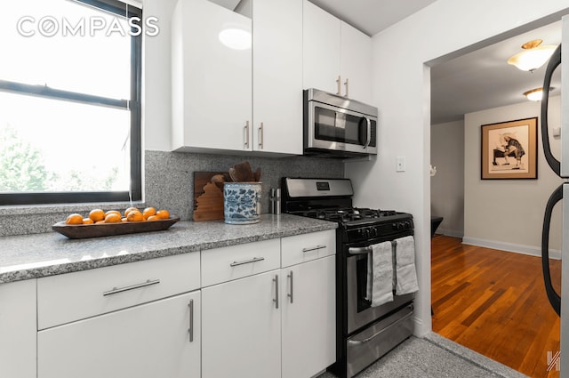 22-40 80th St Unit 3B, New York City, NY 11370 - kitchen featuring stainless steel appliances, backsplash, baseboards, and white cabinets