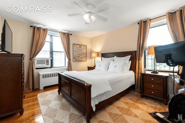 22-40 80th St Unit 3B, New York City, NY 11370 - bedroom with radiator heating unit, multiple windows, light wood-type flooring, and cooling unit