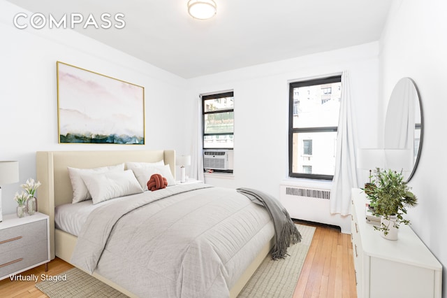 104 E 37th St Unit 5C, New York City, NY 10016 - bedroom featuring radiator, light wood finished floors, and cooling unit