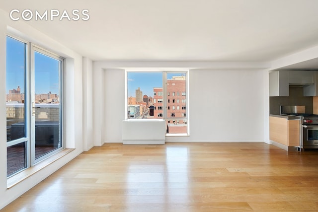 2280 Frederick Douglass Blvd Unit 11E, New York City, NY 10027 - unfurnished living room featuring light wood-style flooring and plenty of natural light