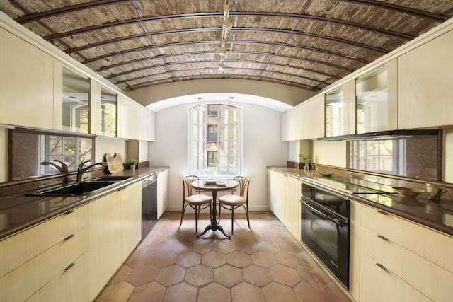 27 W 67th St Unit 2Fe, New York City, NY 10023 - kitchen featuring black appliances, a sink, baseboards, dark tile patterned floors, and lofted ceiling