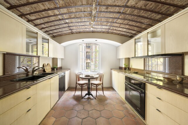 27 W 67th St Unit 2Fe, New York City, NY 10023 - kitchen featuring black oven, dishwasher, cooktop, dark tile patterned flooring, and lofted ceiling