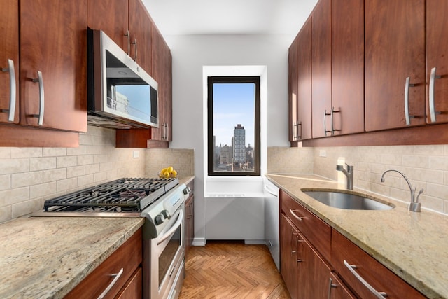 530 E 76th St Unit 20B, New York City, NY 10021 - kitchen with stainless steel appliances, a sink, tasteful backsplash, light stone countertops, and baseboards