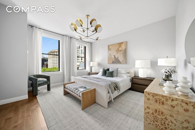 225 5th Ave Unit 7K, New York City, NY 10010 - bedroom with light wood finished floors, a chandelier, and baseboards