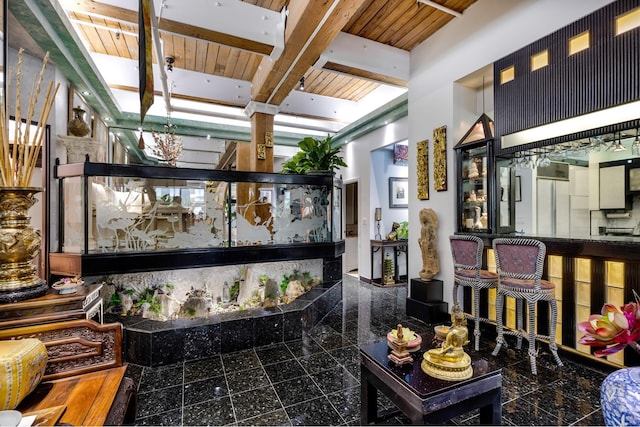 205 E 22nd St Unit 2L, New York City, NY 10010 - living area with granite floors, a wooden ceiling with exposed beams, and a towering ceiling