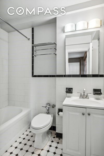 235 E 73rd St Unit 12C, New York City, NY 10021 - bathroom with vanity, toilet, shower / bath combination, and tile walls