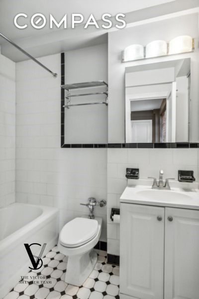 235 E 73rd St Unit 12C, New York City, NY 10021 - full bath featuring vanity, tile walls, and bathing tub / shower combination
