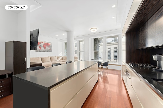 55 Wall St Unit 730, New York City, NY 10005 - kitchen featuring modern cabinets, dark countertops, wood finished floors, and recessed lighting