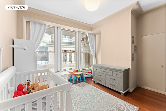 55 Wall St Unit 730, New York City, NY 10005 - bedroom with dark wood finished floors, a nursery area, and baseboards