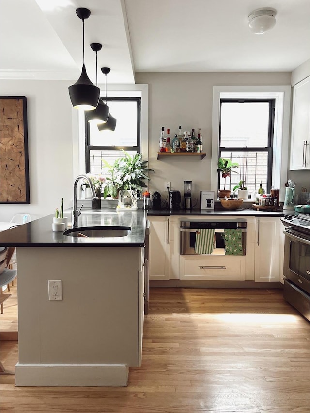 1890 Adam C Powell Blvd Unit 5C, New York City, NY 10026 - kitchen featuring a sink, stainless steel electric stove, dark countertops, and light wood-type flooring