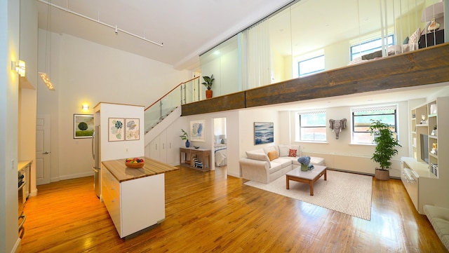259 21st St Unit 1C, New York City, NY 11215 - living room with a high ceiling, wood finished floors, stairway, and track lighting