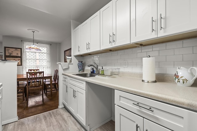 315 W 232nd St Unit 3-C, New York City, NY 10463 - kitchen with light wood finished floors, light countertops, white cabinetry, and decorative backsplash
