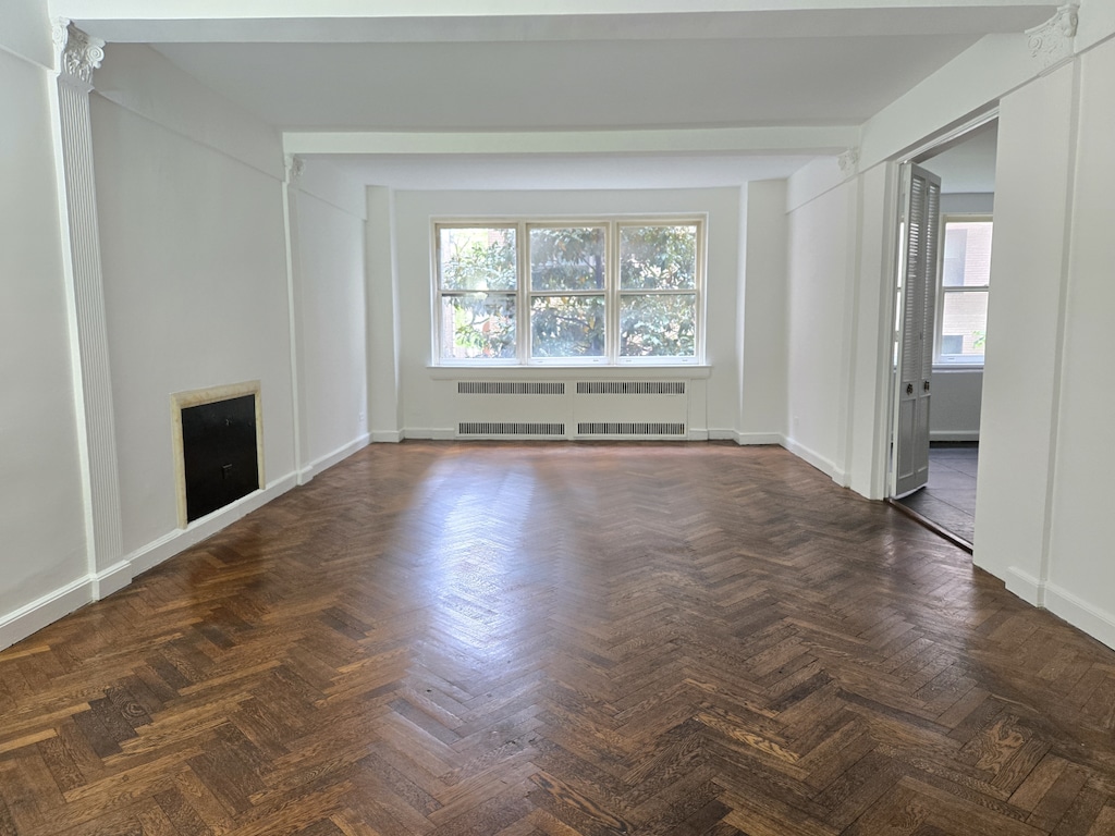 3 E 69th St Unit 3/4C, New York City, NY 10021 - unfurnished living room with radiator and baseboards