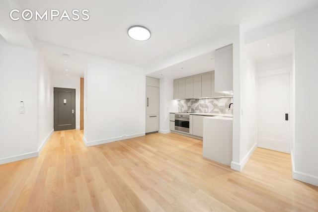 176 W 87th St Unit 1H, New York City, NY 10024 - unfurnished living room with light wood-style floors and baseboards