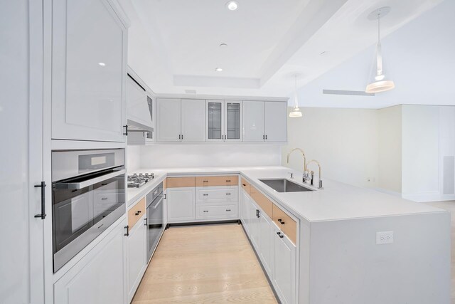 21 E 61st St Unit 9D, New York City, NY 10065 - kitchen with stainless steel appliances, a peninsula, glass insert cabinets, recessed lighting, and light countertops