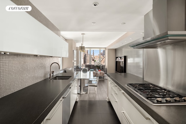 408 E 79th St Unit 9A, New York City, NY 10075 - kitchen with stainless steel gas cooktop, a sink, dark tile patterned floors, white cabinets, and ventilation hood