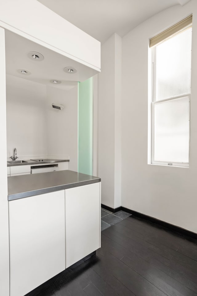 27 W 67th St Unit 8Rew, New York City, NY 10023 - kitchen featuring white cabinets, a sink, dark wood-style floors, and baseboards