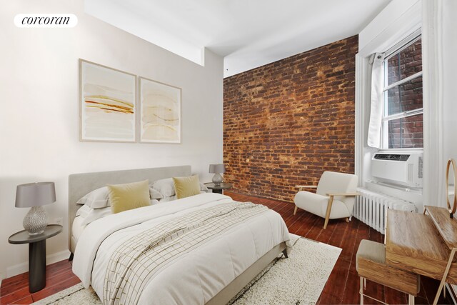 324 E 50th St Unit 4D, New York City, NY 10022 - bedroom featuring radiator heating unit, brick wall, wood finished floors, and cooling unit
