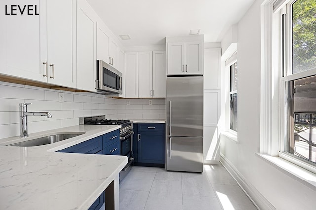 200 W 108th St Unit 2-E, New York City, NY 10025 - kitchen featuring high quality appliances, blue cabinets, a sink, decorative backsplash, and white cabinets