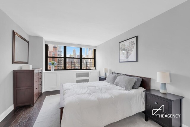 239 E 79th St Unit 12A, New York City, NY 10075 - bedroom featuring dark wood-type flooring and baseboards
