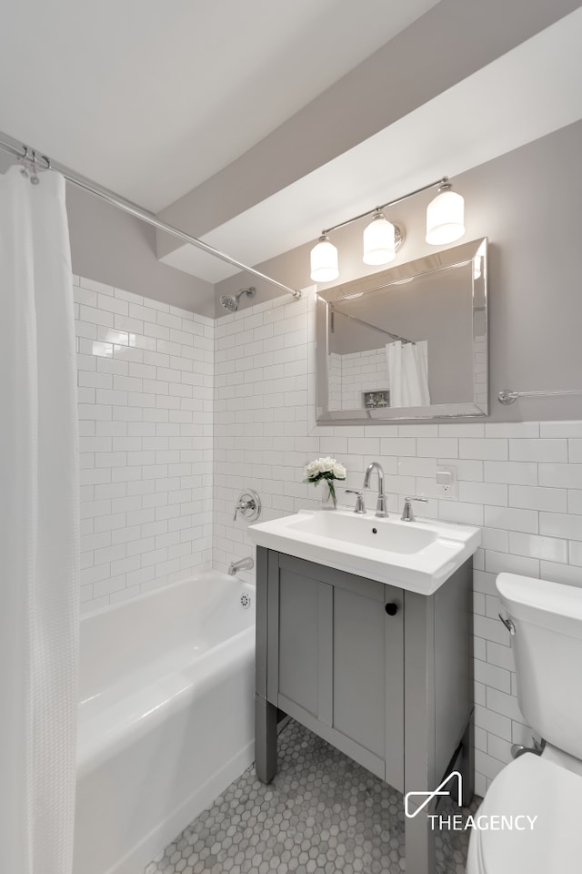 239 E 79th St Unit 12A, New York City, NY 10075 - full bath featuring vanity, shower / bathtub combination with curtain, tile walls, and tile patterned floors