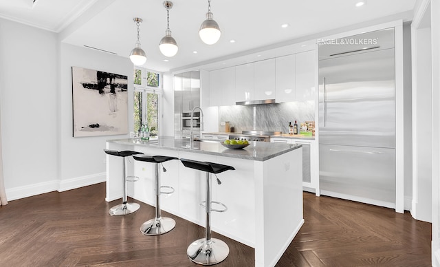 344 W 72nd St Unit 203, New York City, NY 10023 - kitchen featuring built in fridge, modern cabinets, white cabinets, a center island with sink, and a breakfast bar