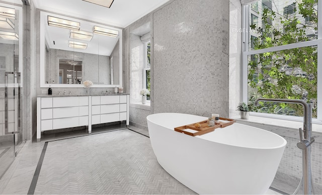 344 W 72nd St Unit 203, New York City, NY 10023 - bathroom featuring vanity, a freestanding bath, tile walls, inlaid floor details, and an enclosed shower
