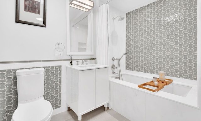 344 W 72nd St Unit 203, New York City, NY 10023 - full bathroom featuring tile walls, vanity, shower / bathtub combination with curtain, tile patterned flooring, and wainscoting