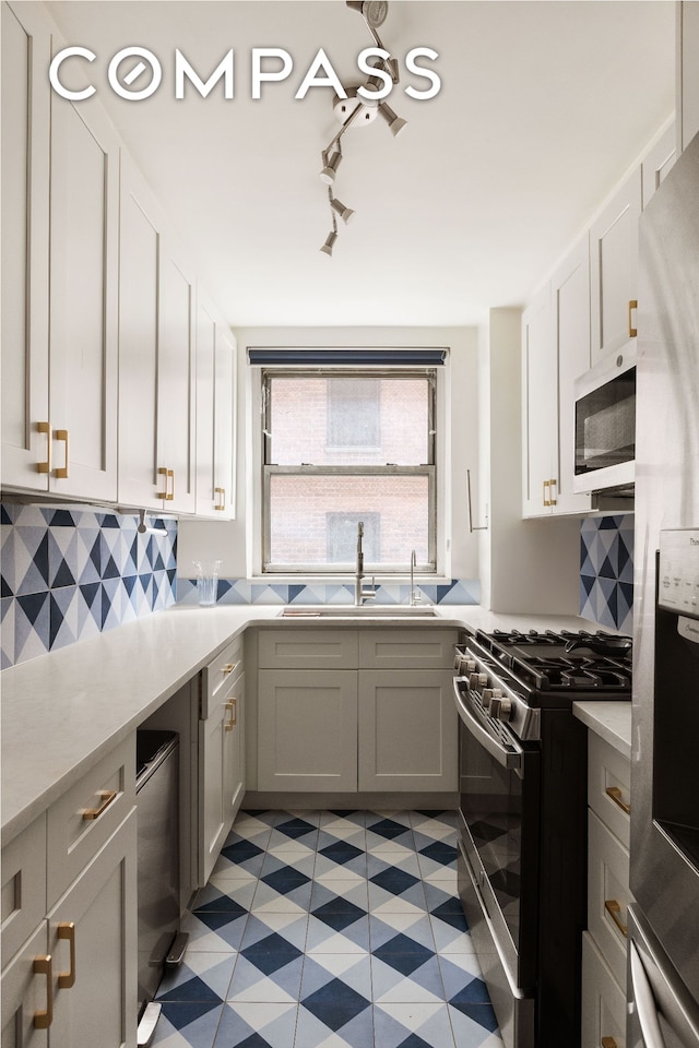 495 E 7th St Unit 2F, New York City, NY 11218 - kitchen with stainless steel appliances, a sink, light countertops, light flooring, and backsplash