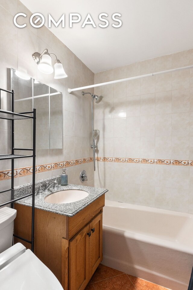 495 E 7th St Unit 2F, New York City, NY 11218 - bathroom with vanity, tile patterned floors, shower / bathtub combination, and tile walls