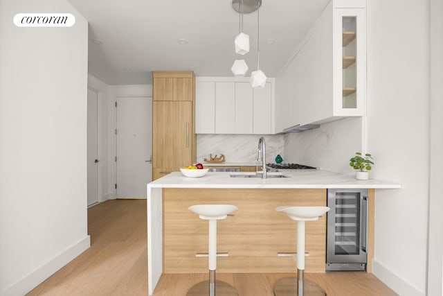 184 Hawthorne St Unit 3A, New York City, NY 11225 - kitchen featuring beverage cooler, a breakfast bar, a peninsula, a sink, and modern cabinets