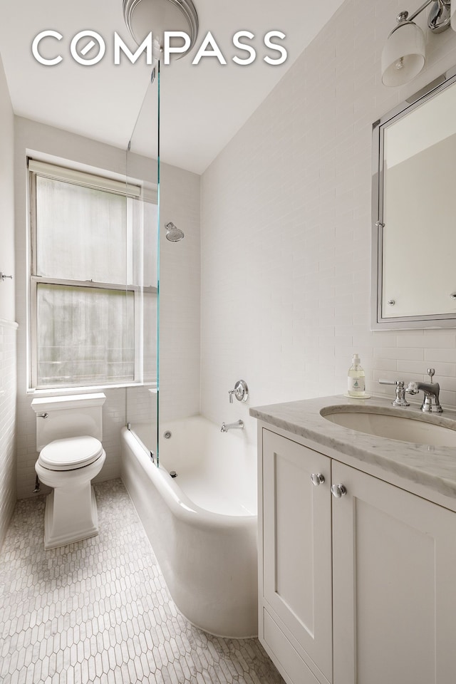 201 W 89th St Unit 2F, New York City, NY 10024 - bathroom featuring tile walls, toilet, vanity, and shower / bath combination