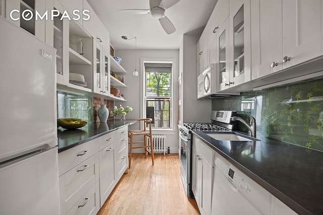 162 Garfield Pl Unit 1L, New York City, NY 11215 - kitchen featuring white appliances, radiator heating unit, decorative backsplash, and dark countertops
