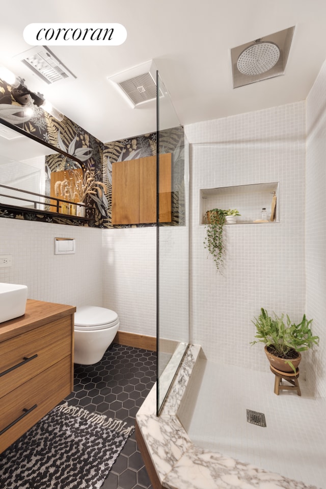 61 Engert Ave Unit 1, New York City, NY 11222 - bathroom featuring a tile shower, vanity, tile patterned flooring, and toilet