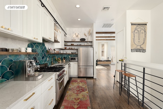 61 Engert Ave Unit 1, New York City, NY 11222 - kitchen with stainless steel appliances, open shelves, a sink, light stone counters, and decorative backsplash