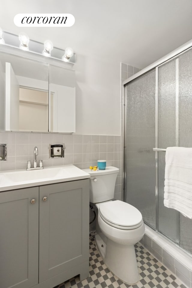 150 E 77th St Unit 3D, New York City, NY 10075 - full bathroom with vanity, toilet, a shower stall, wainscoting, and tile walls