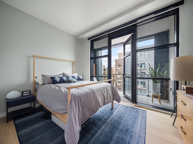 215 N 10th St Unit 4F, New York City, NY 11211 - bedroom with access to outside, a wall of windows, and light wood-style floors